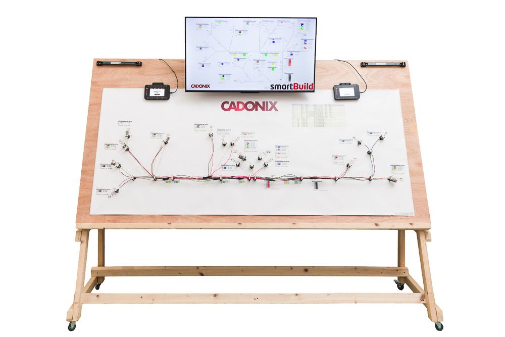 Cadonix electronic circuit training board on wooden easel stand with monitor displaying circuit diagrams.