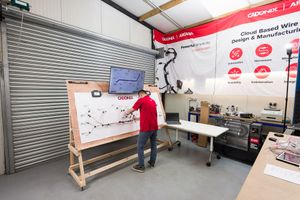 A technician presents a wire design diagram on a whiteboard at Cadonix wire loom design and manufacturing facility.