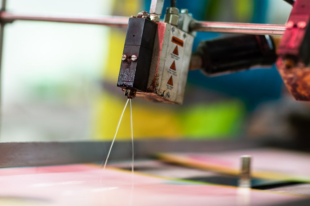 Factory photography | close up of automated glue gun for magazine production