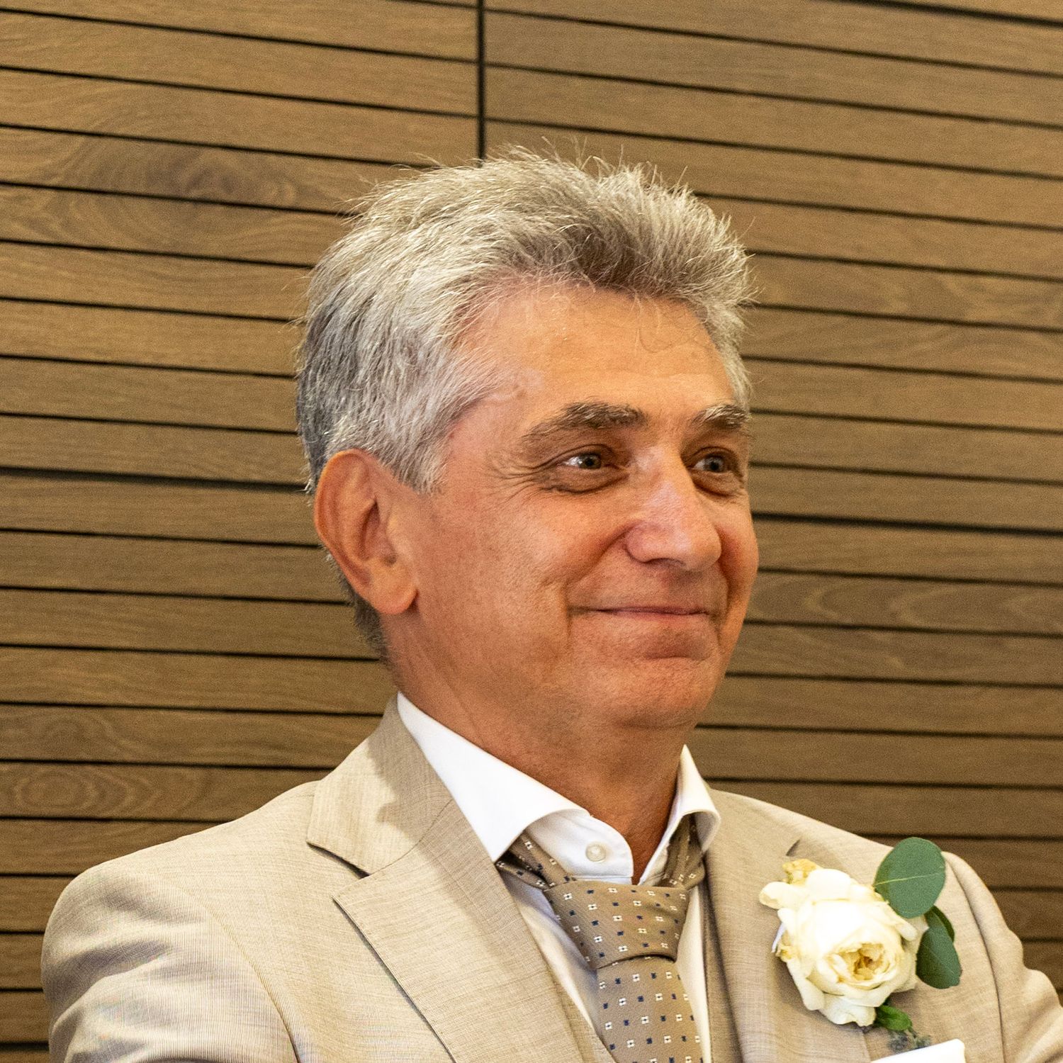 Portrait du marié en costume beige avec une boutonnière, pendant la cérémonie civile.