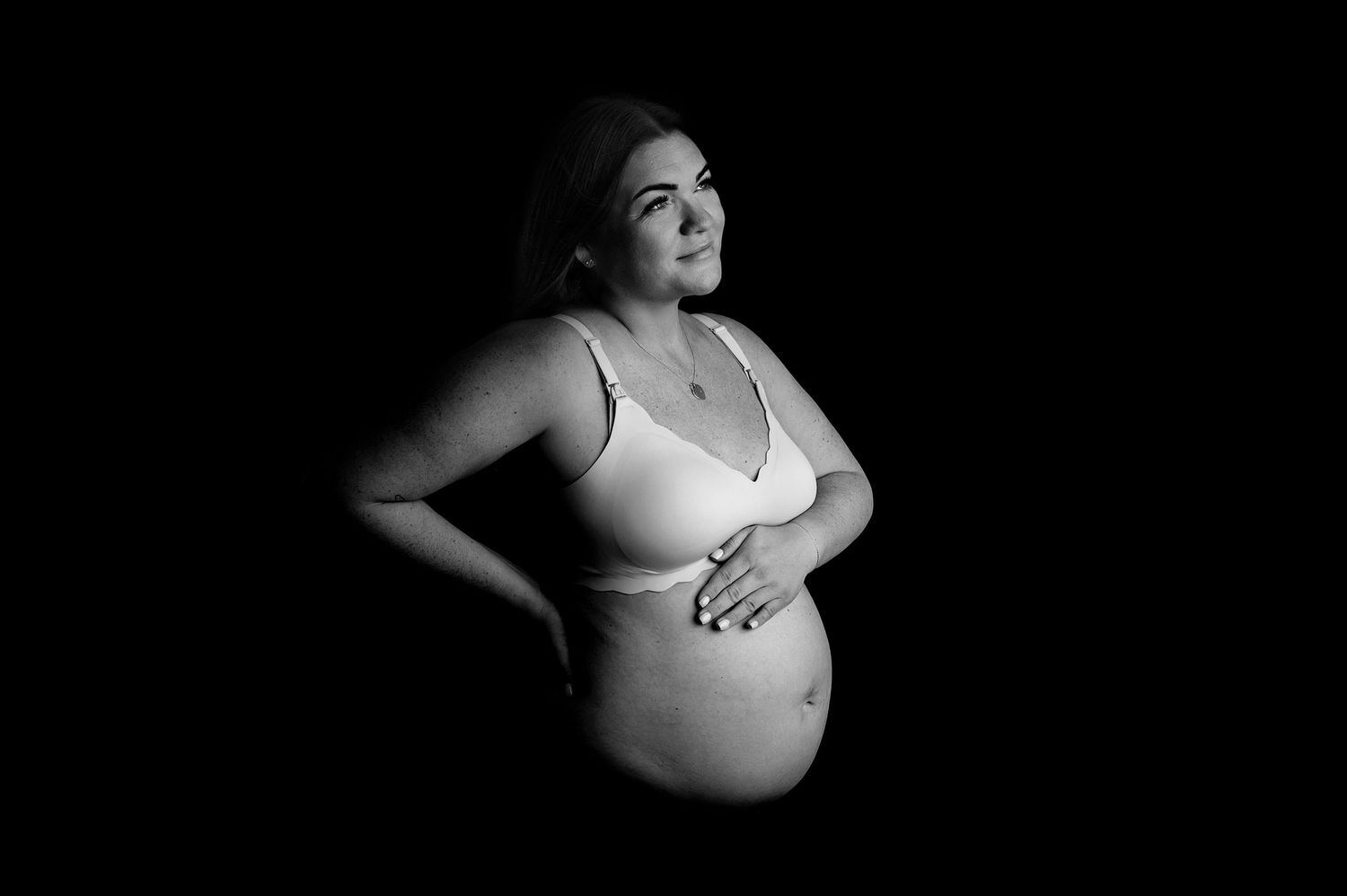 A series of artistic maternity photos showing a pregnant woman's silhouette against a dark background.