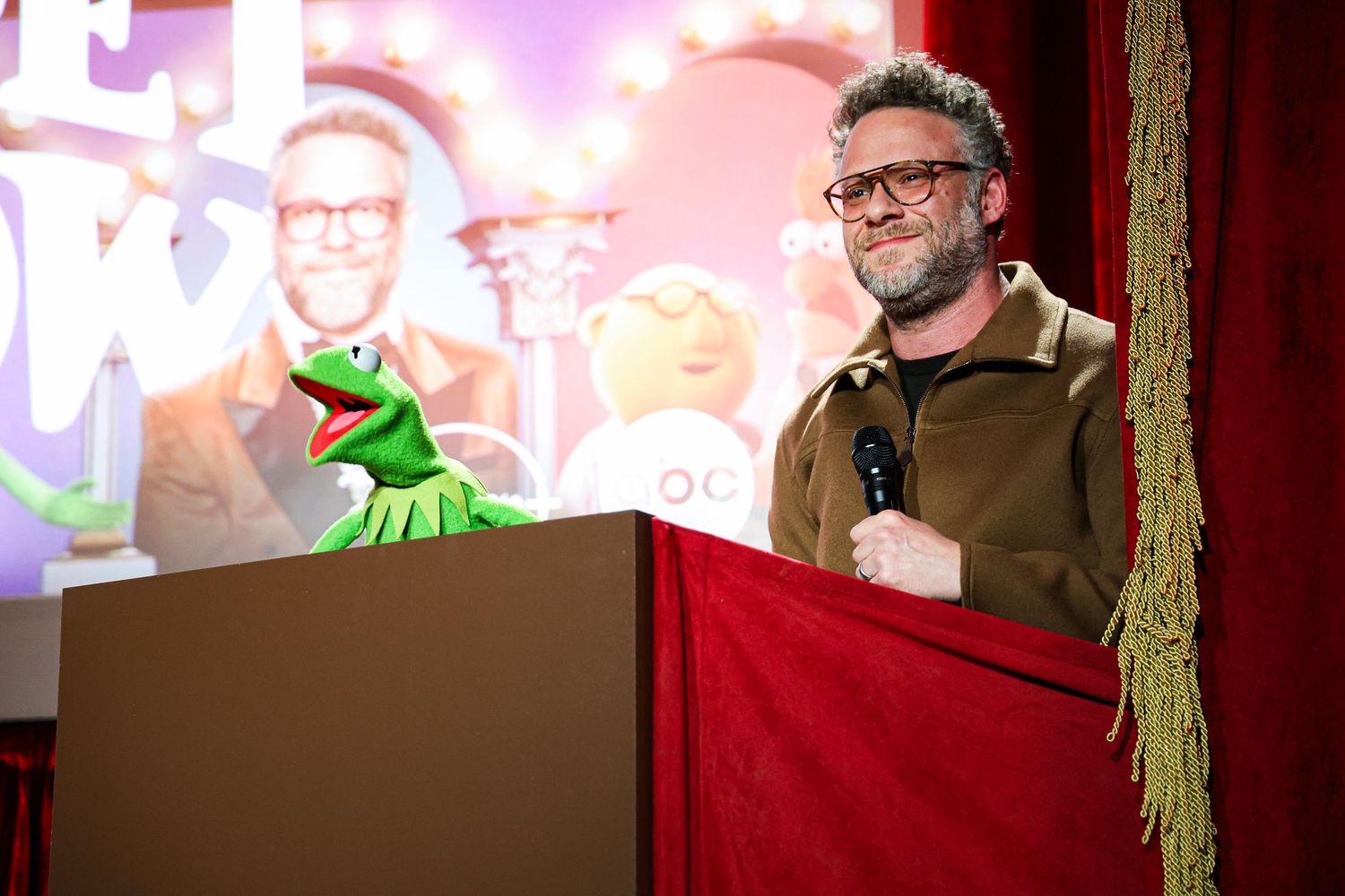 Seth Rogen hosting The Muppet Show premiere next to Kermit the Frog at The Roosevelt in Los Angeles.