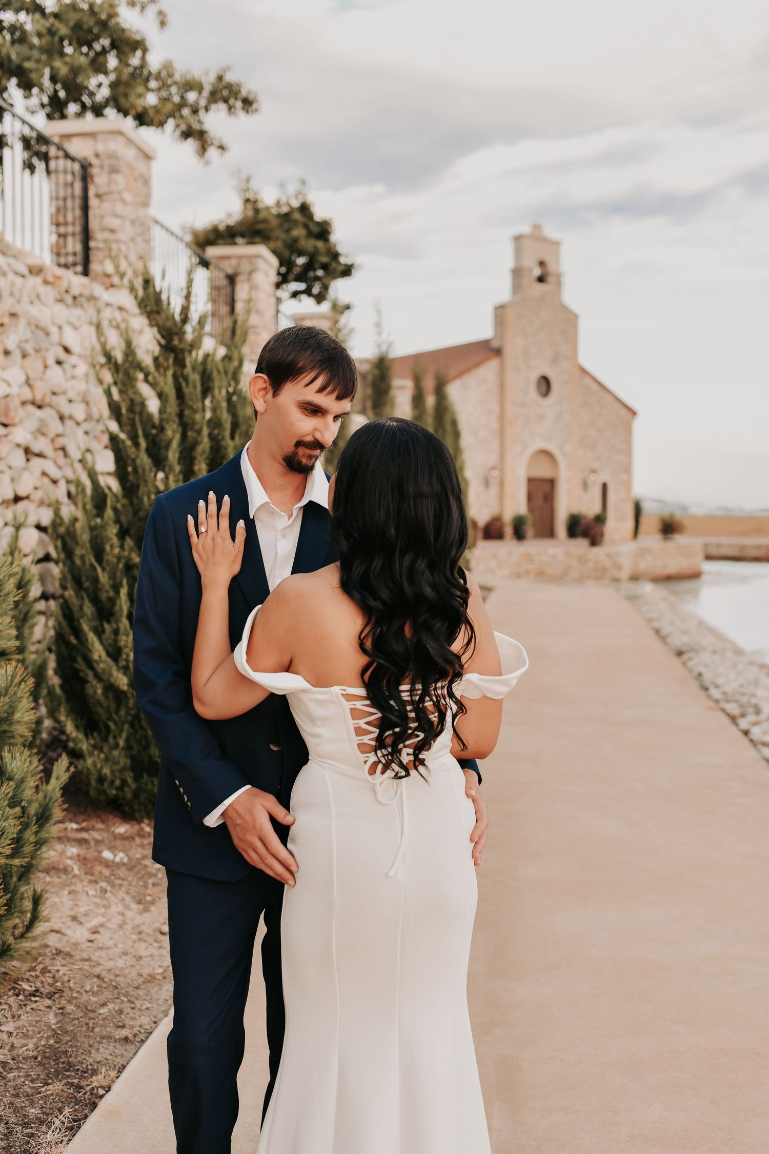 Bride-to-be showing movement in her white dress during romantic waterfront engagement photos