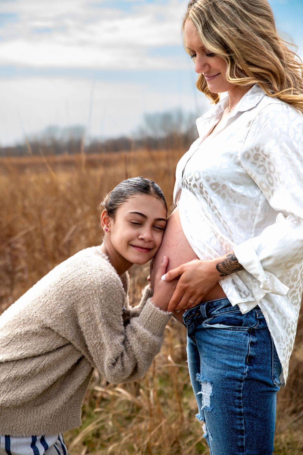 Expectant mother and daughter embracing during a maternity photography session in St. Marys, Ohio