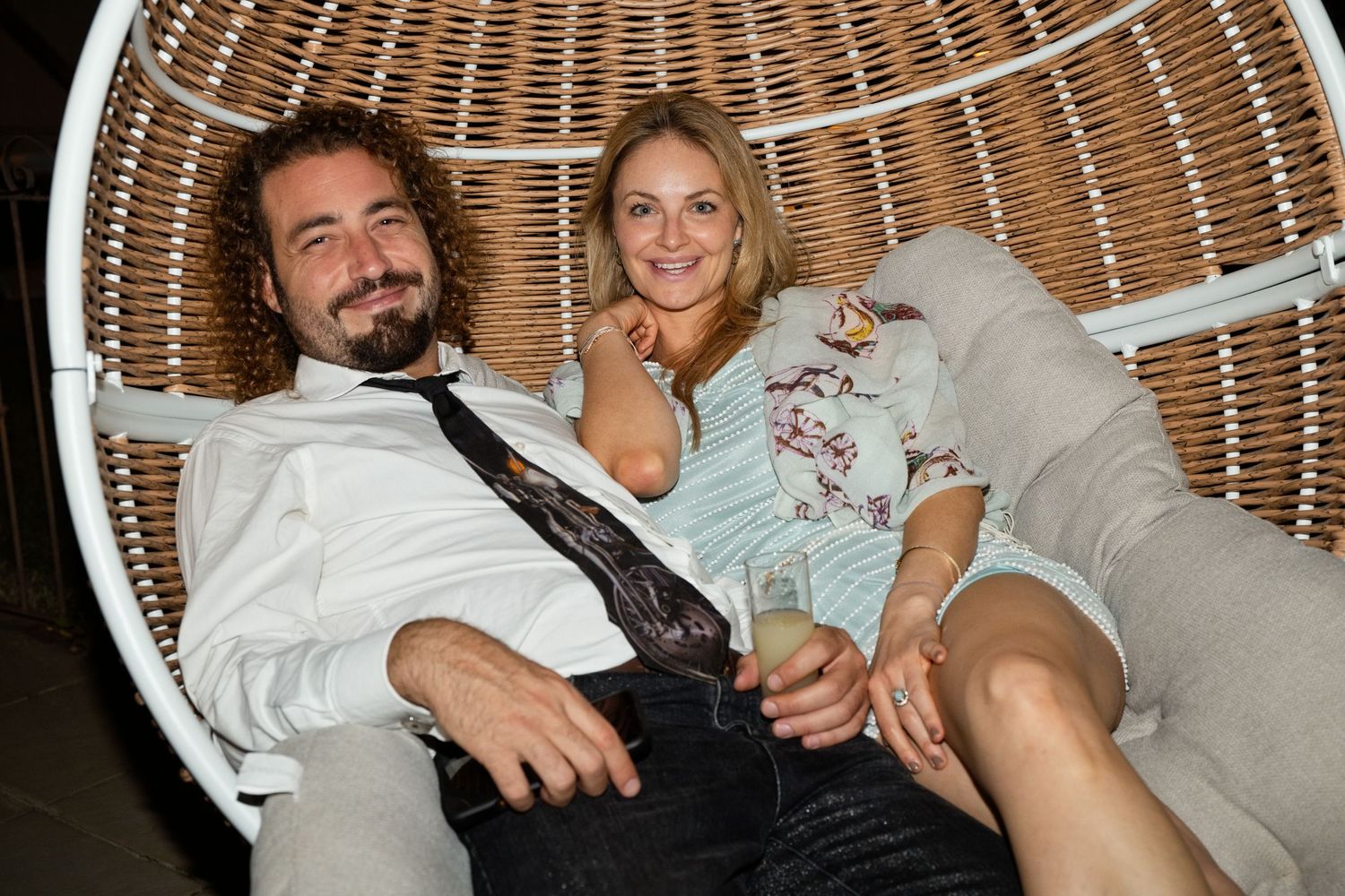 Deux invités profitent d’un moment dans un fauteuil pendant la soirée de mariage.