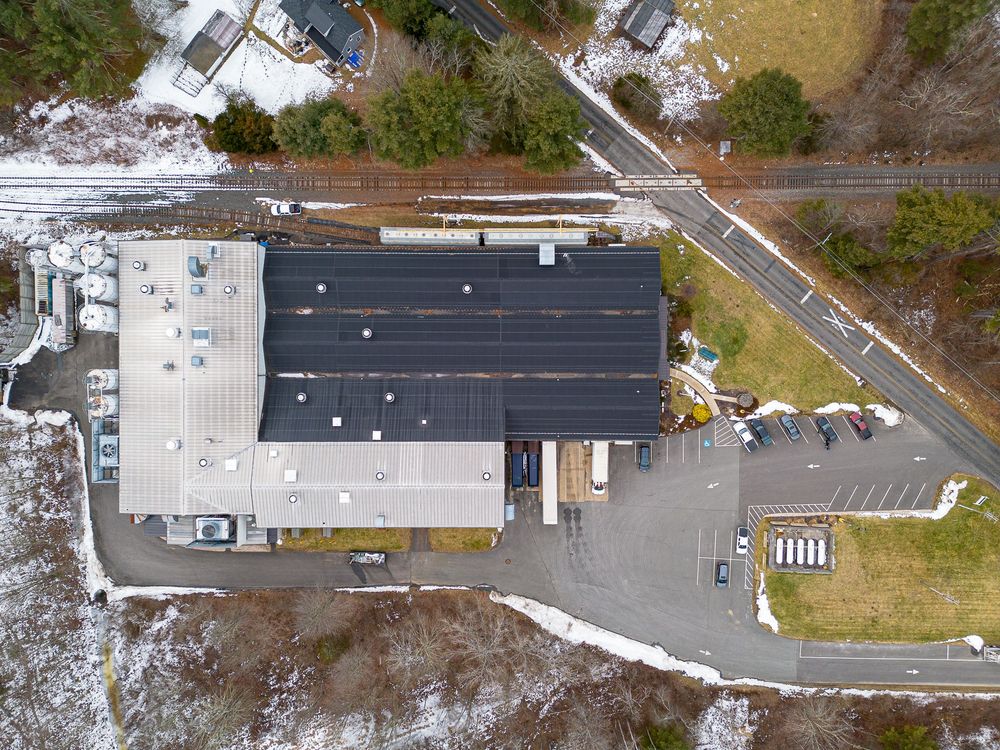 Aerial top-down view of a commercial building with solar panels on roof and parking lot.