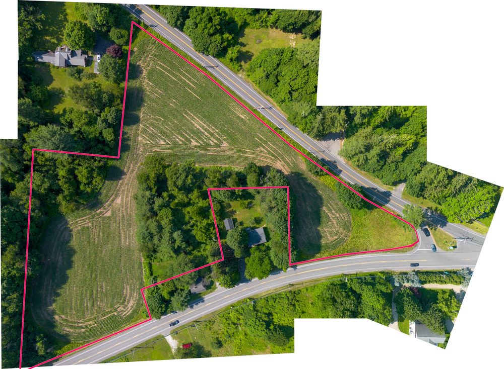 Aerial map view of a triangular parcel of land outlined in red along a rural highway intersection.