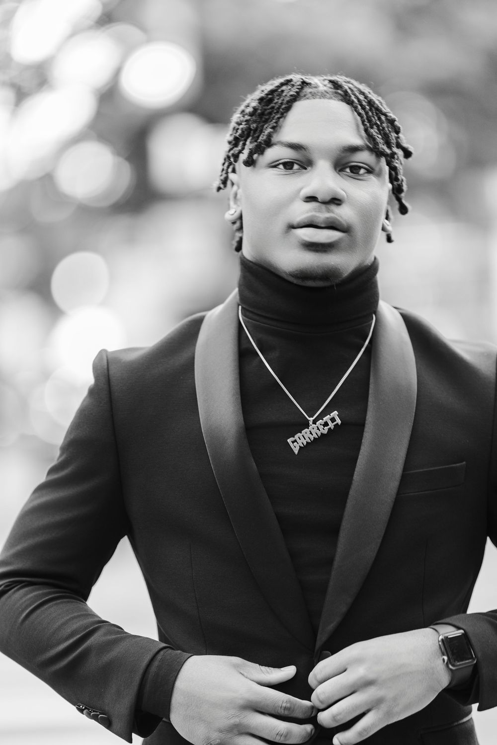 Black and white portrait series showing a person in a black blazer and turtleneck against a blurred background.