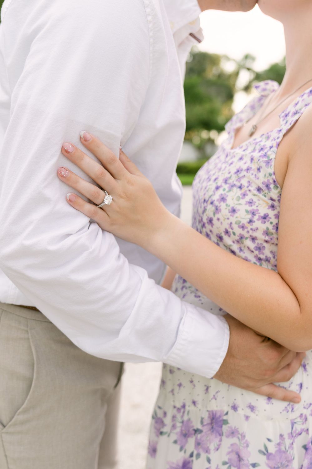 Close-up of an engagement ring as a couple embraces during their Jekyll Island engagement portrait session.