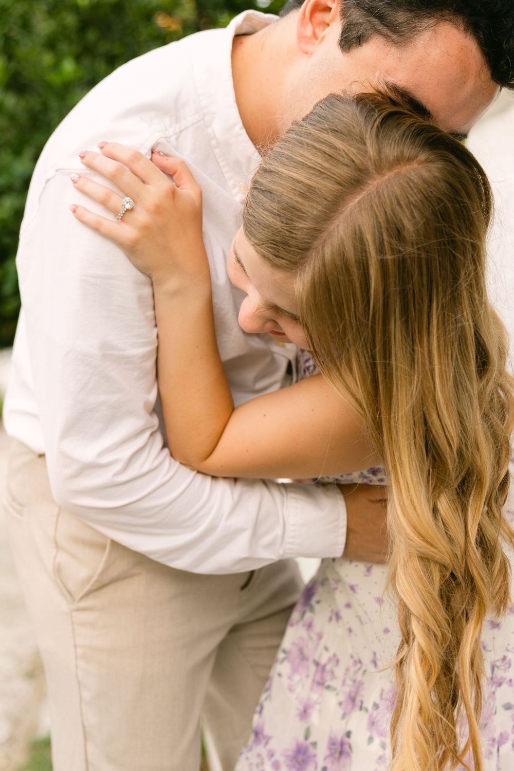 Close-up of an engaged couple playing, with her diamond ring visible during their Jekyll Island portrait session.