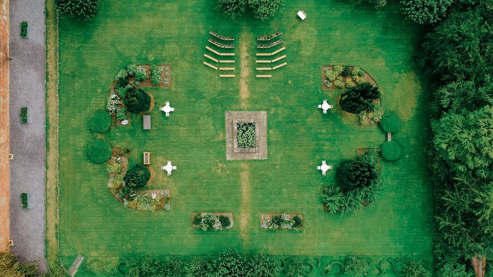Aerial view of symmetrical garden with manicured lawn and ornamental plantings.