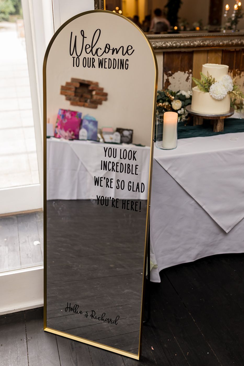 Gold-framed wedding welcome mirror sign reading Welcome to Our Wedding, You Look Incredible, signed by Hollie and Richard.