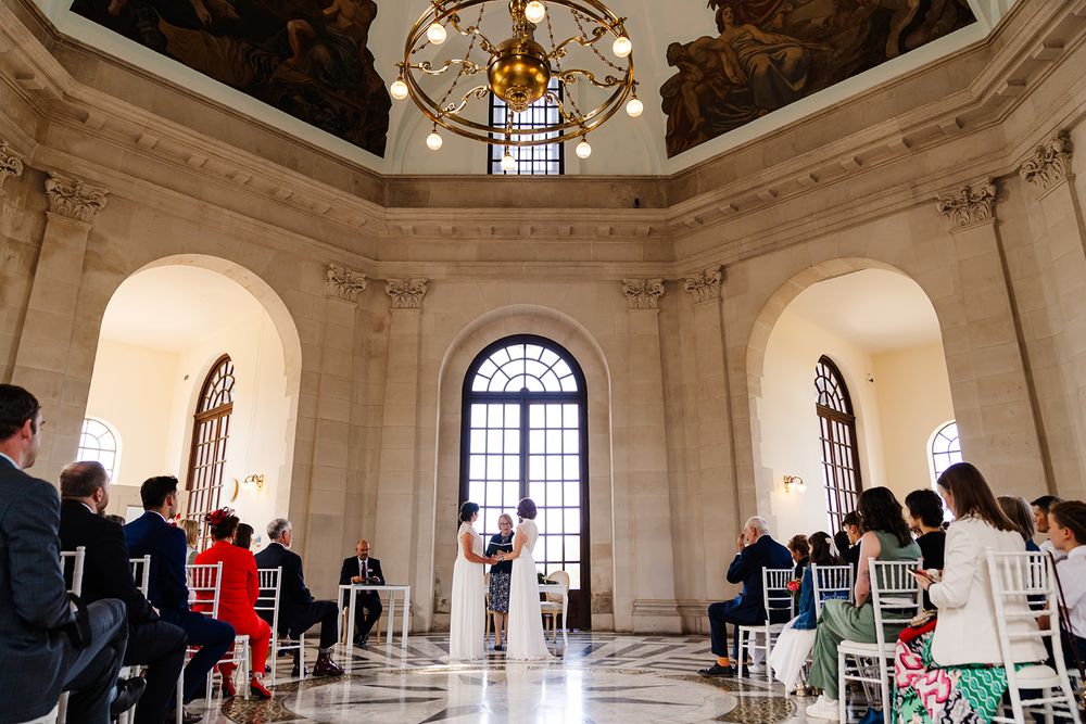 Candid wedding ceremony photos of a same sex wedding beneath the historic domed ceiling at Ashton Memorial