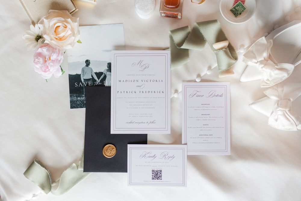 Elegant wedding invitation suite with save the date, menu card, and QR code RSVP card on white satin fabric.