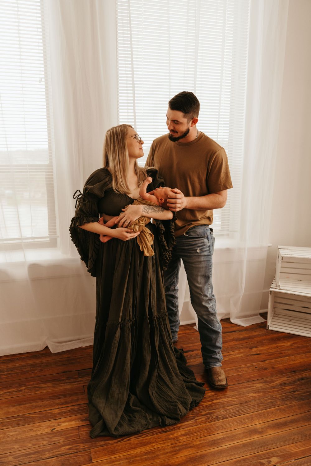 Couple dancing together in sunlit room with wooden floors and white curtains.