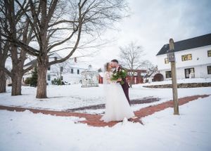 Winter wedding scene with snow covered ground and classic buildings in background.