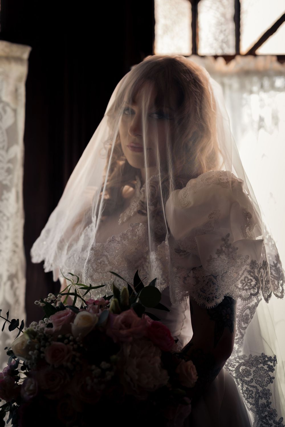 a veiled bride in back light at her wedding at the Edwards manion in redlands