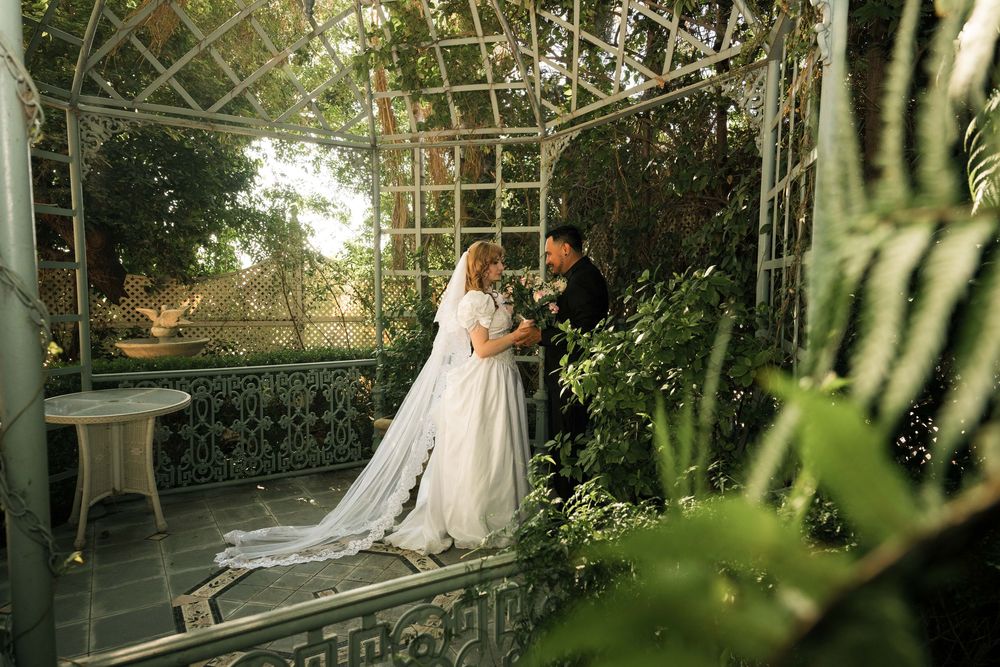 a bride and groom embrace in an open gazebo at the Edwards Manion in Redlands after their wedding