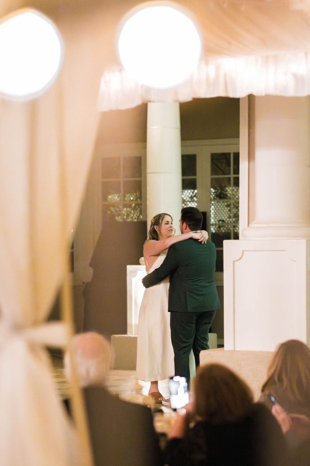 Bride and groom share their first dance surrounded by guests during the wedding reception, captured by Chris Cornish Photography.