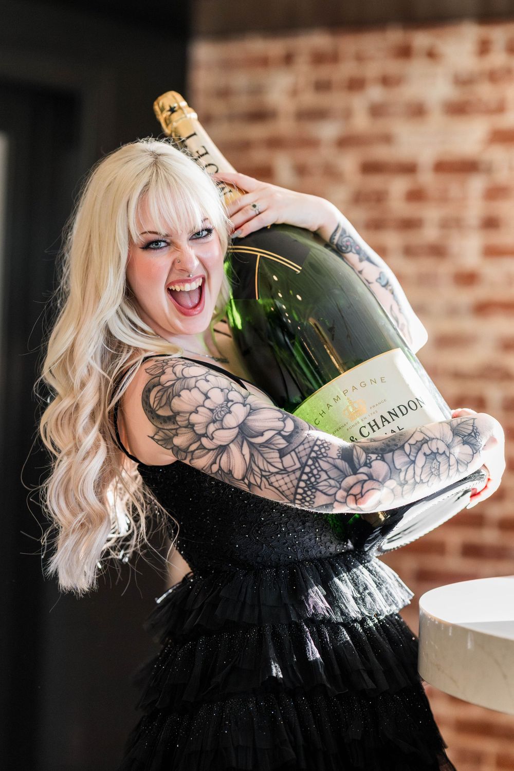 Bride in her wedding attire holding a giant champagne bottle. taken by Chris Cornish Photography