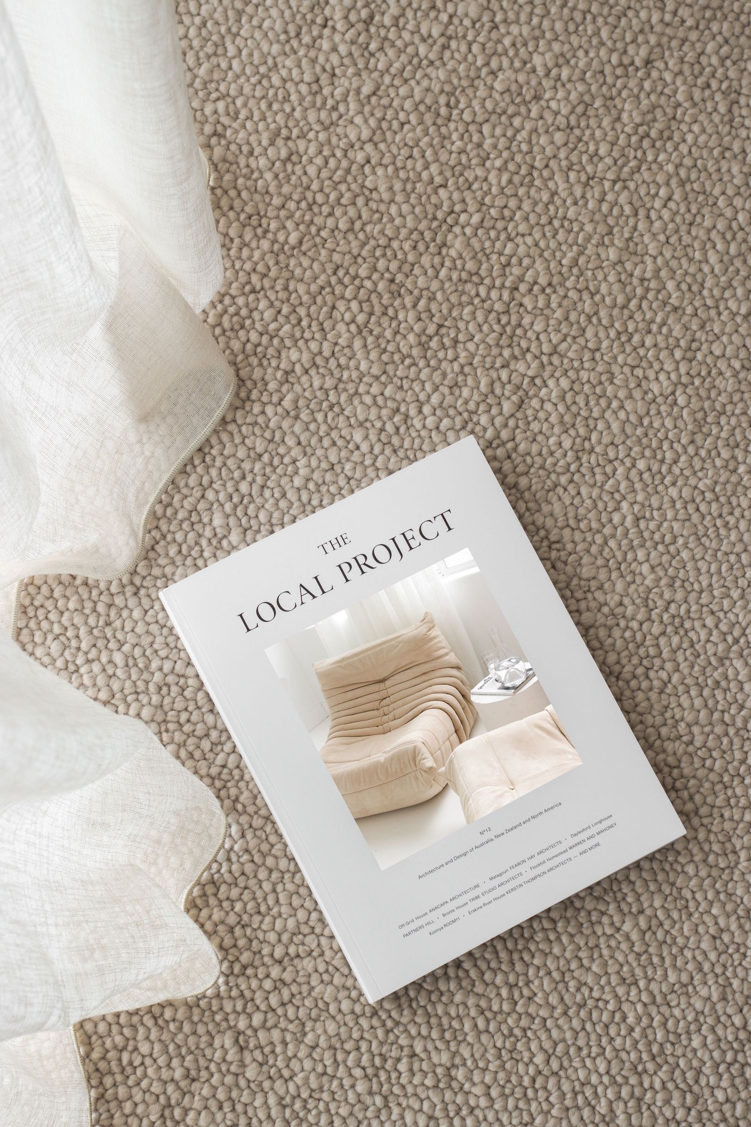 Business cards with neutral color swatches and tissue paper on textured carpet.