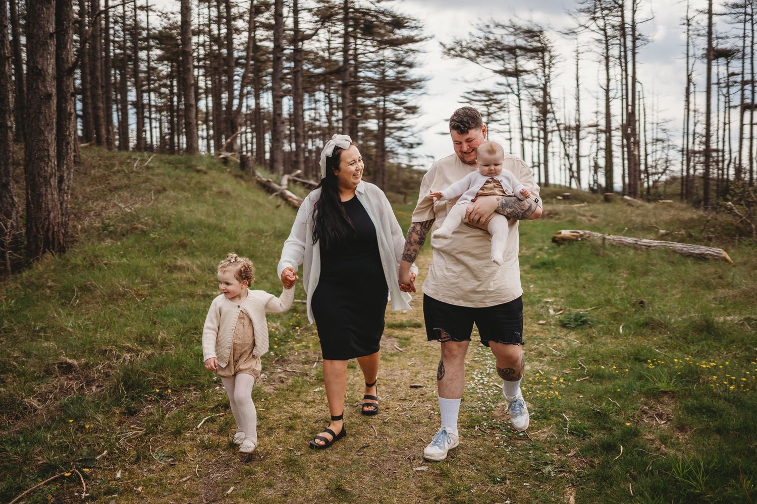 Family walking together through a pine forest on a cloudy day.