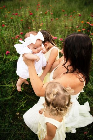 A tender moment captured in a wildflower field with bright red and yellow blooms in the background.
