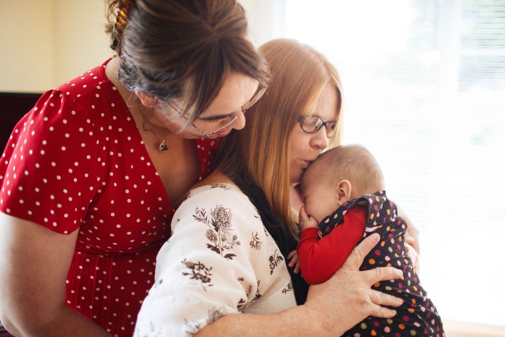seattle family photographer: A queer couple with their newborn daughter at an in-home family photo session