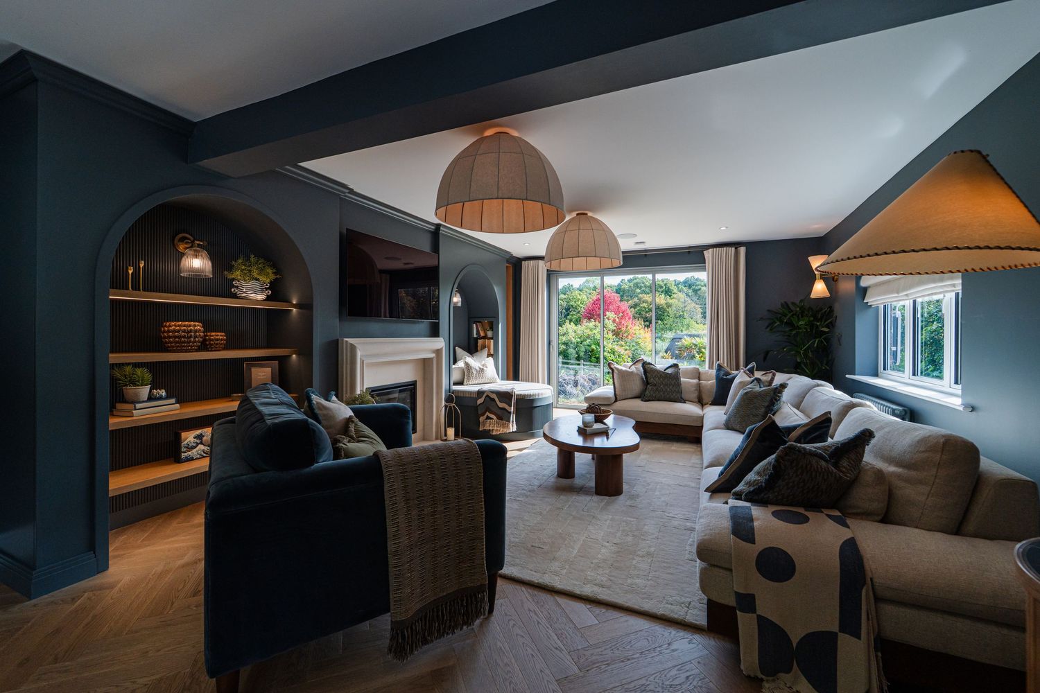 Modern loft apartment interior with sloped ceilings, grey sectional sofa, and contemporary decor in neutral tones.