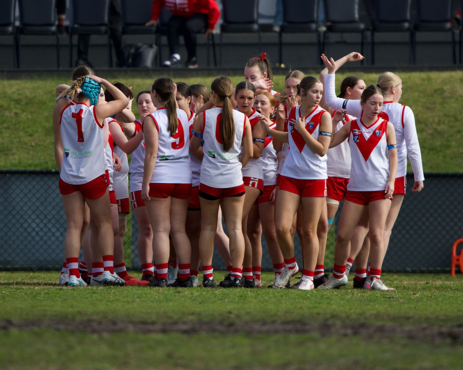 Junior girls football team huddle