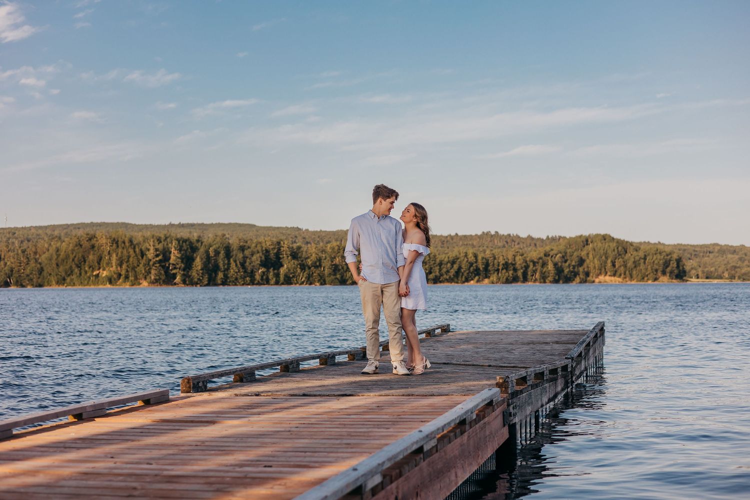 A romantic golden hour embrace between a couple standing in a sunlit autumn field.