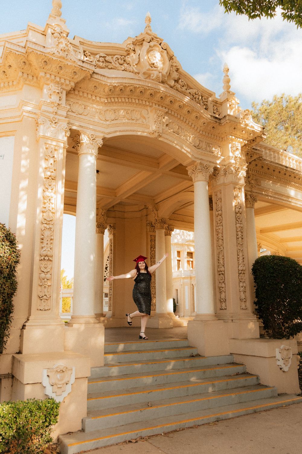 Ornate classical stone colonnade with decorative architectural details and steps at entrance of historic building in warm sunlight.