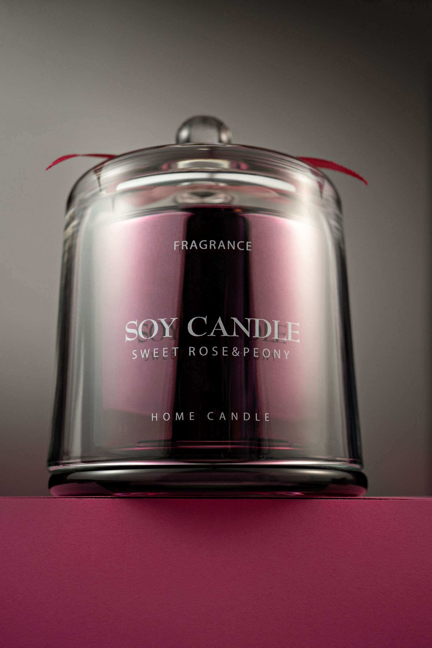 A luxurious soy candle in glass jar with 'Sweet Rose & Peony' fragrance label against dark background.