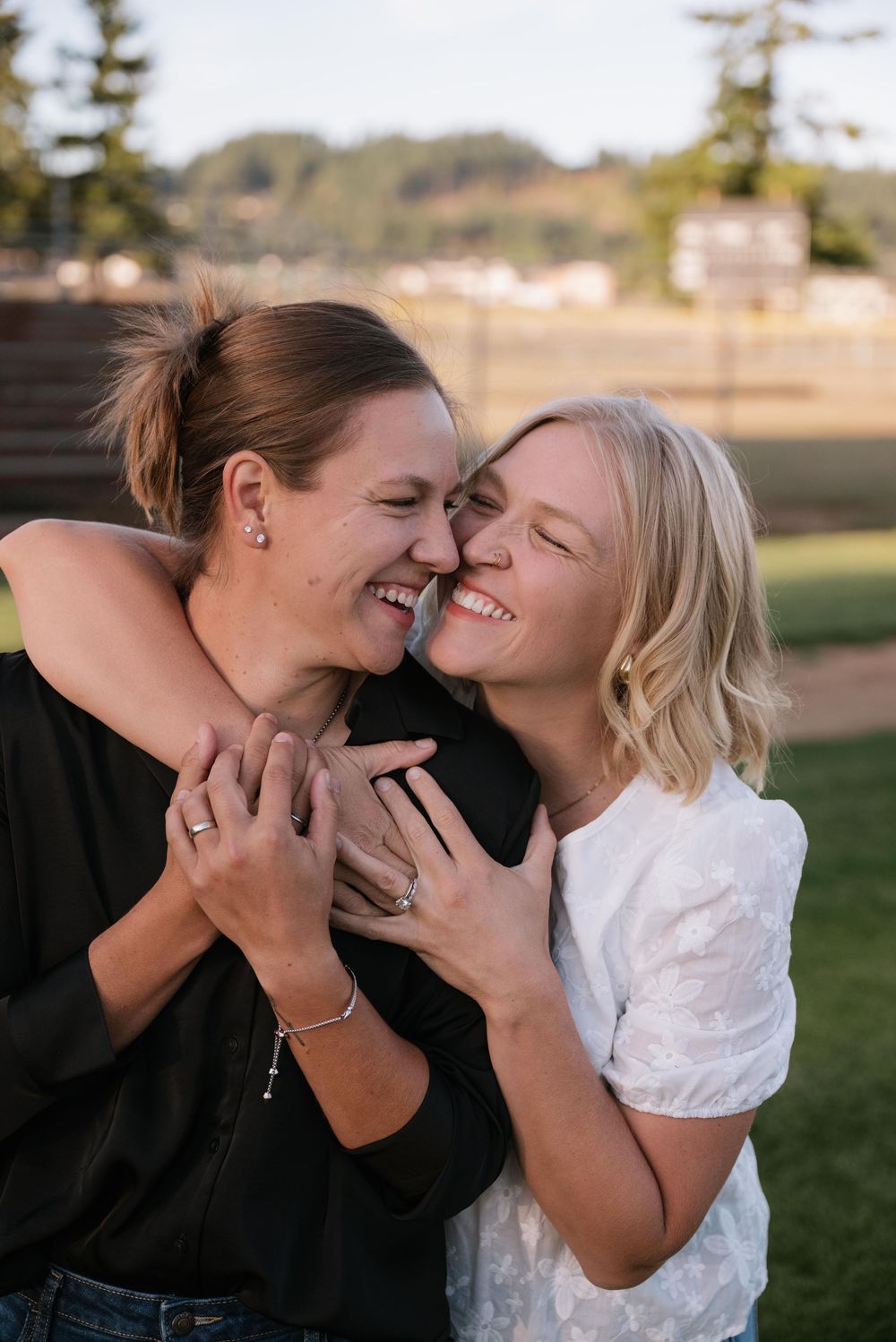 A couple shares tender moments of laughter and affection in an outdoor setting during a photo series.