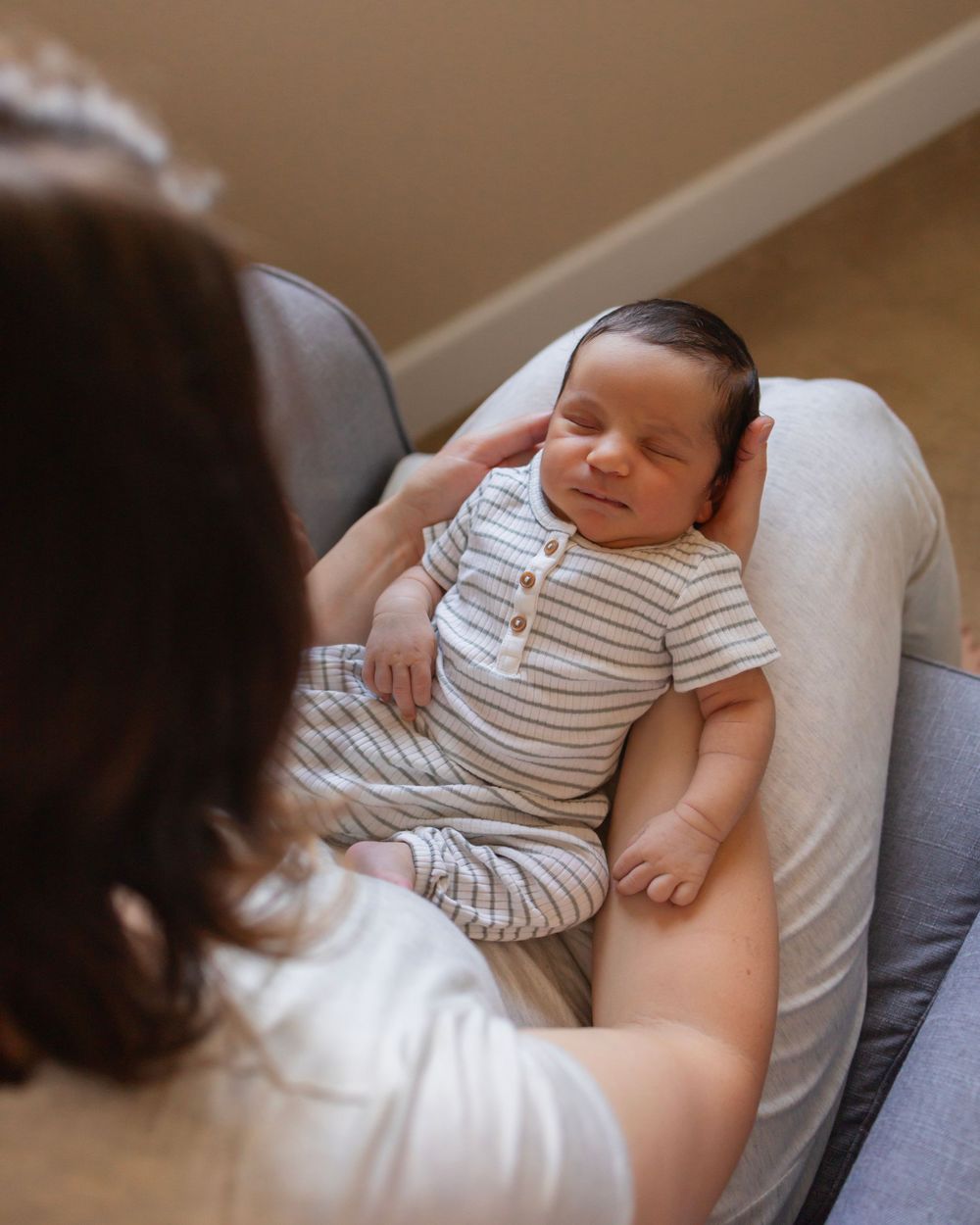 birds eye view of a sleeping baby boy on mothers lap