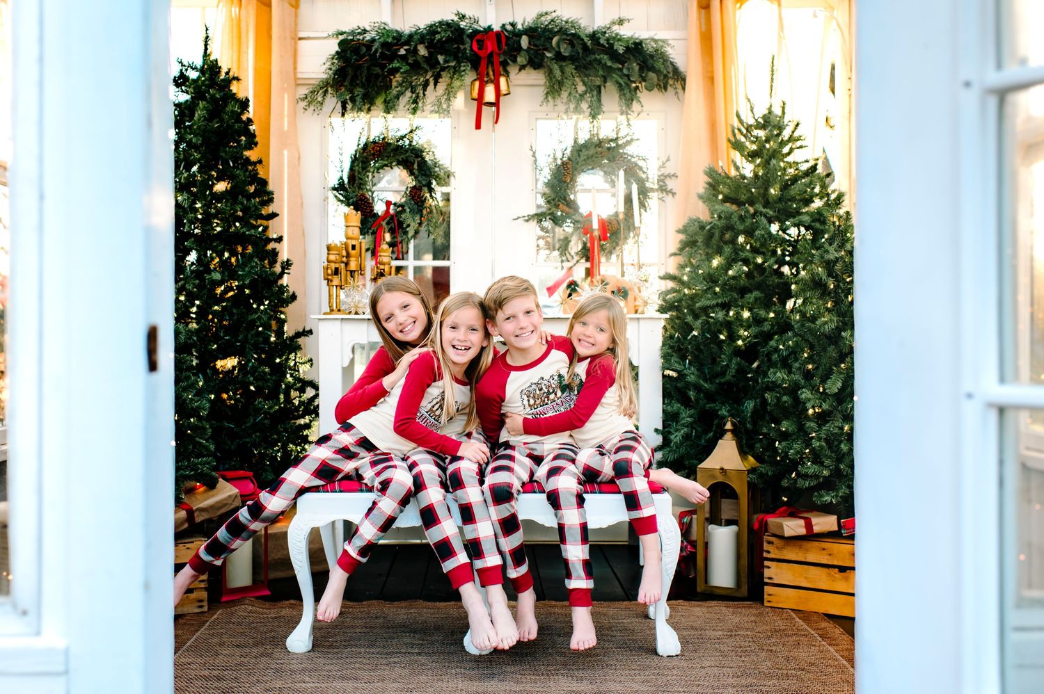 Tulsa, Oklahoma; the Victorian Greenhouse Christmas pajama session with kids wearing Christmas pjs with red and Christmas decor