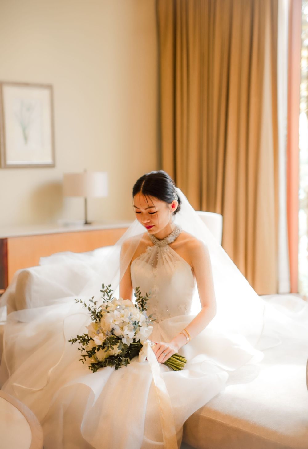 Indoor wedding shoot of the bride preparing for their actual day ceremony, captured by a wedding photographer in Singapore