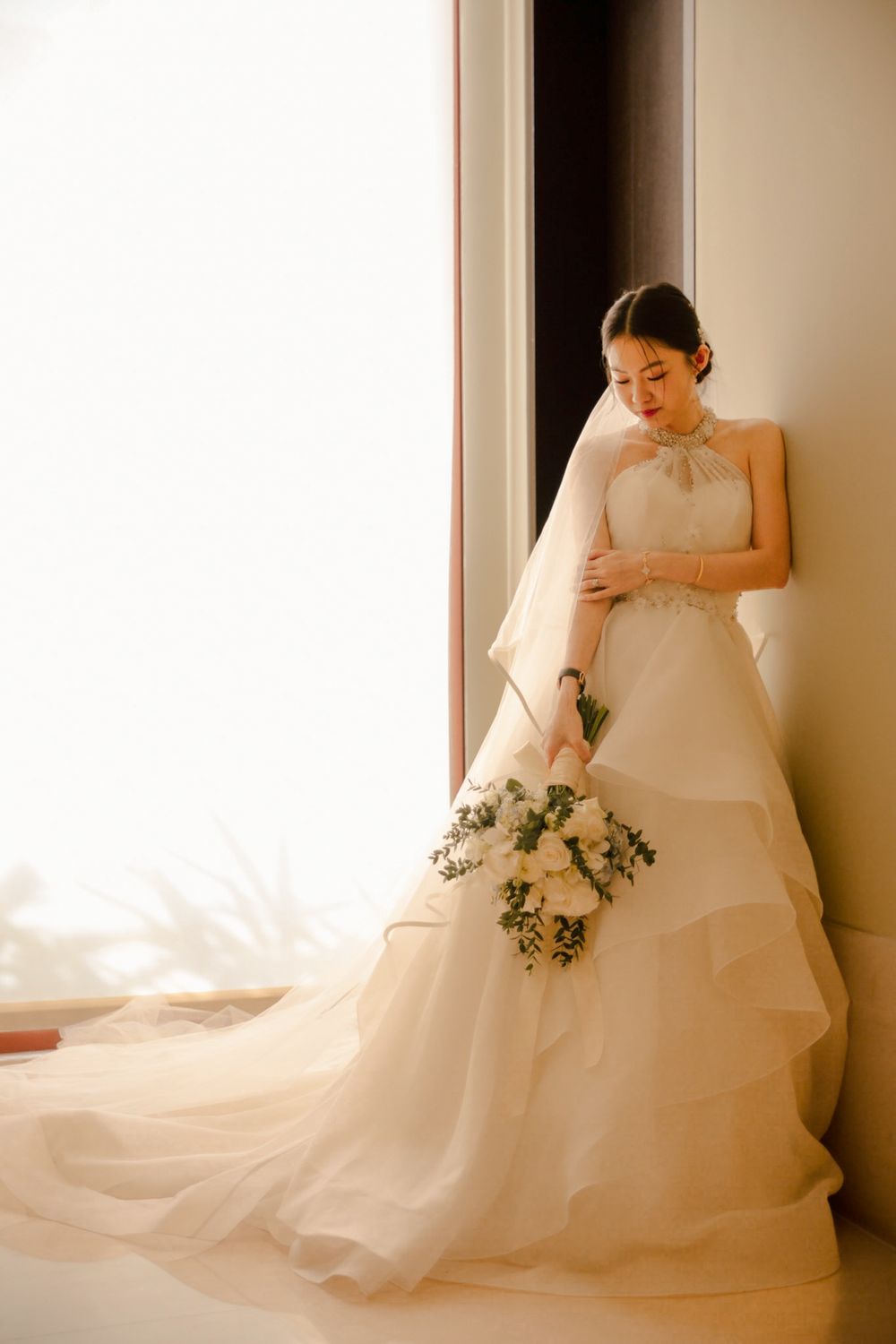 Indoor wedding shoot of the bride and groom preparing for their actual day ceremony, captured by a wedding photographer in Singapore