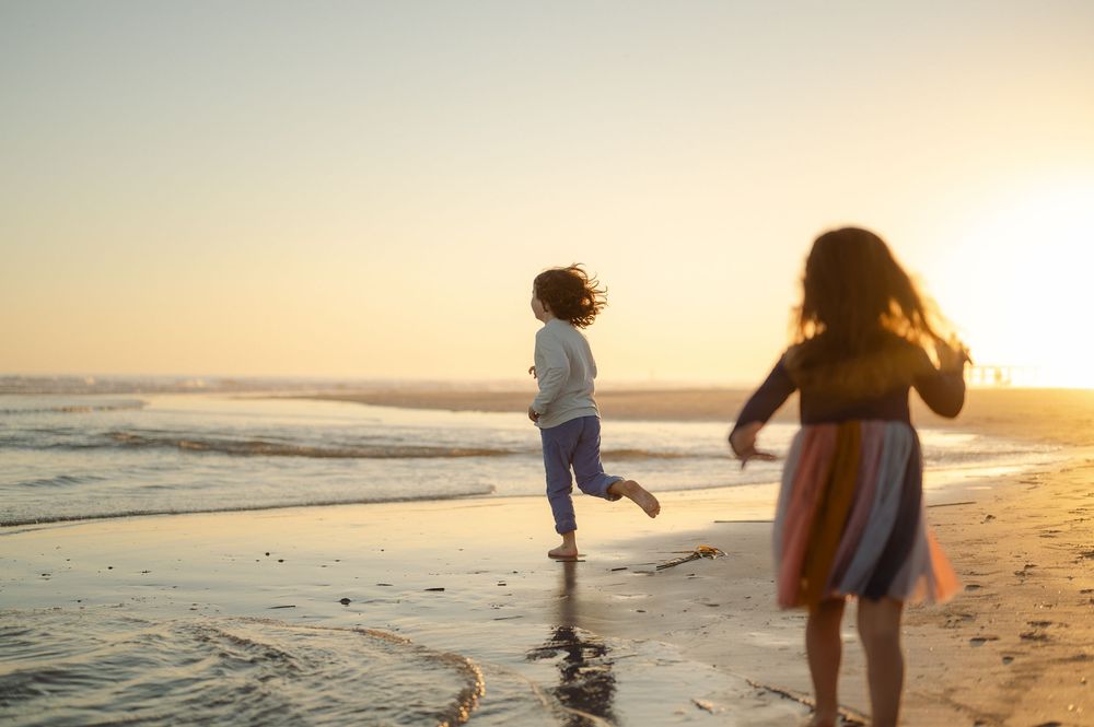 kids running on the beach playing during sunset