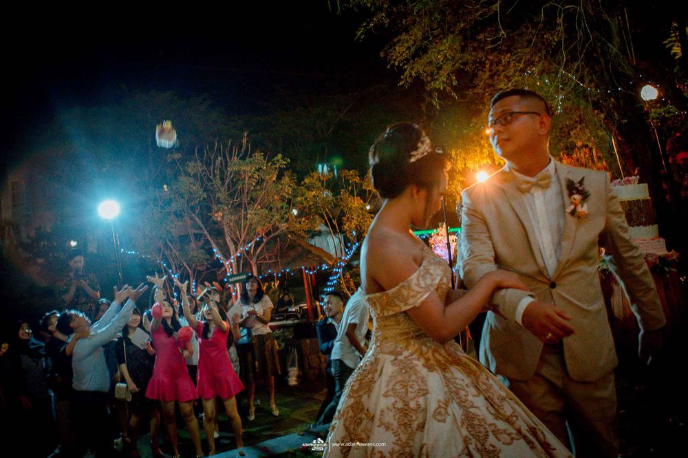 Wedding celebration at night with guests holding sparklers while dancing.