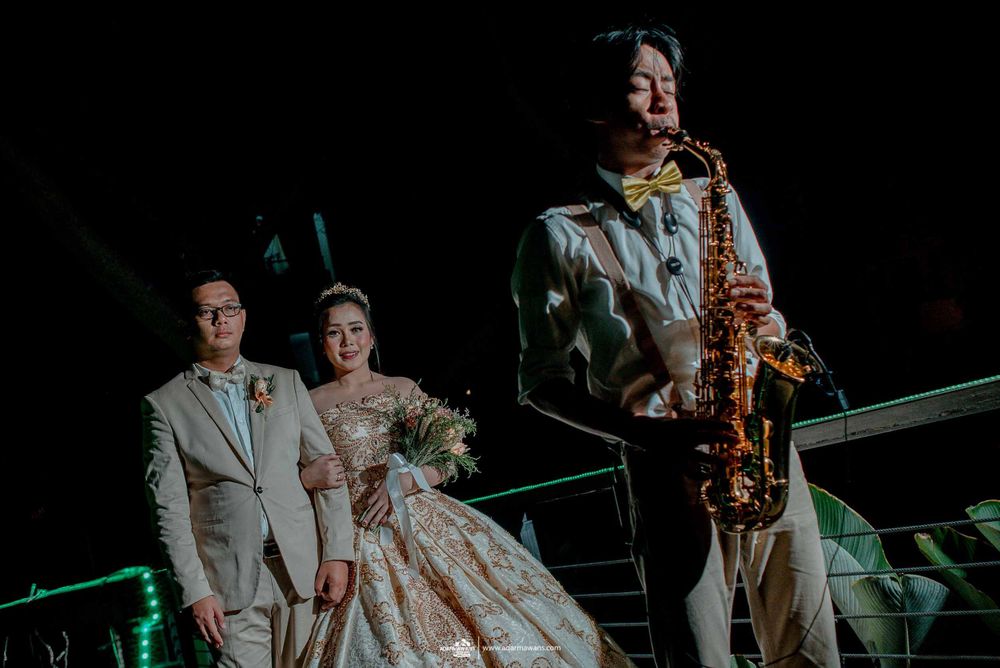 A saxophonist performs during an elegant wedding reception at night.