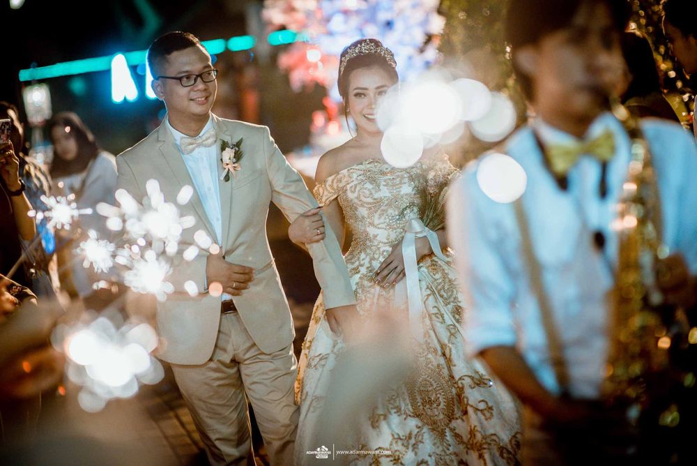 A celebratory wedding moment with sparklers creating magical light effects in the evening.
