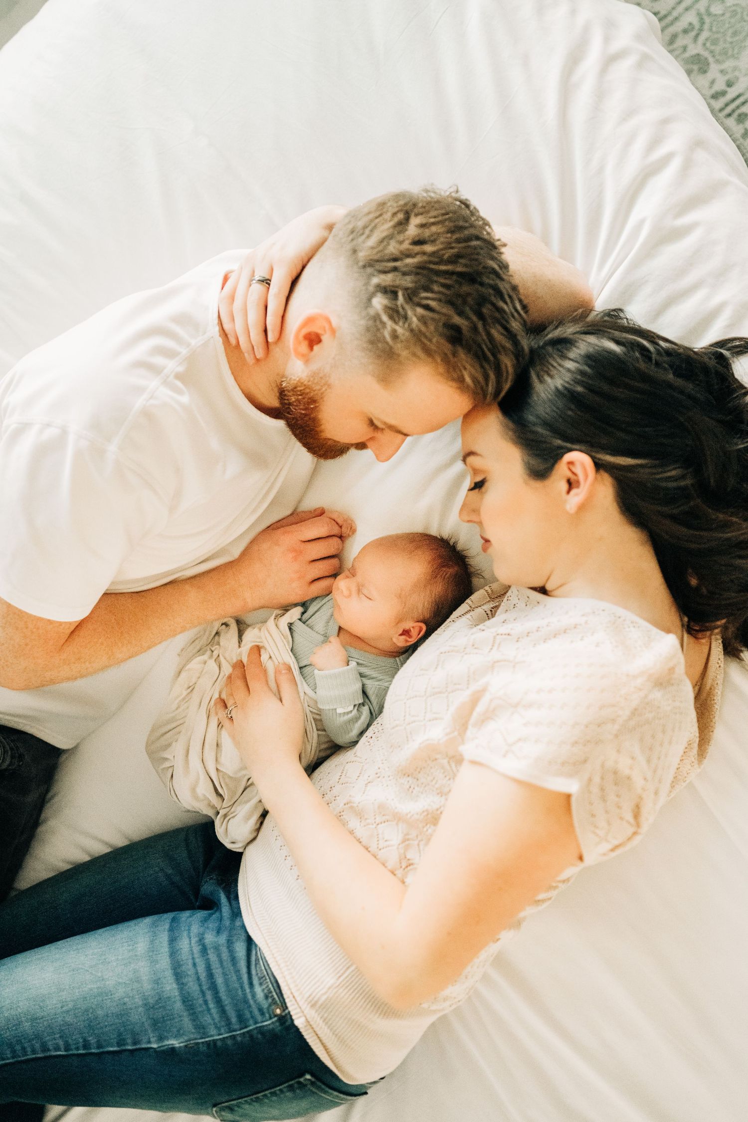 laying on a bed during an in home newborn session in Frisco, TX