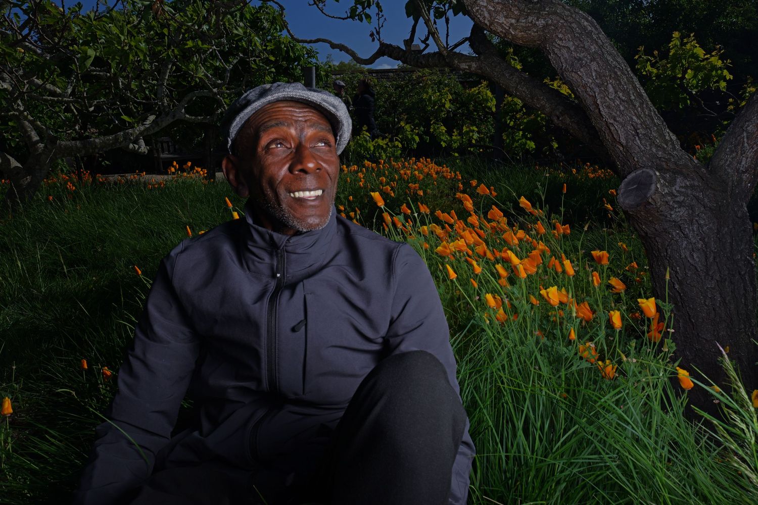 Handsome black man sitting in field of poppy flowers during the superbloom 2023 on the central coast Monterey CA