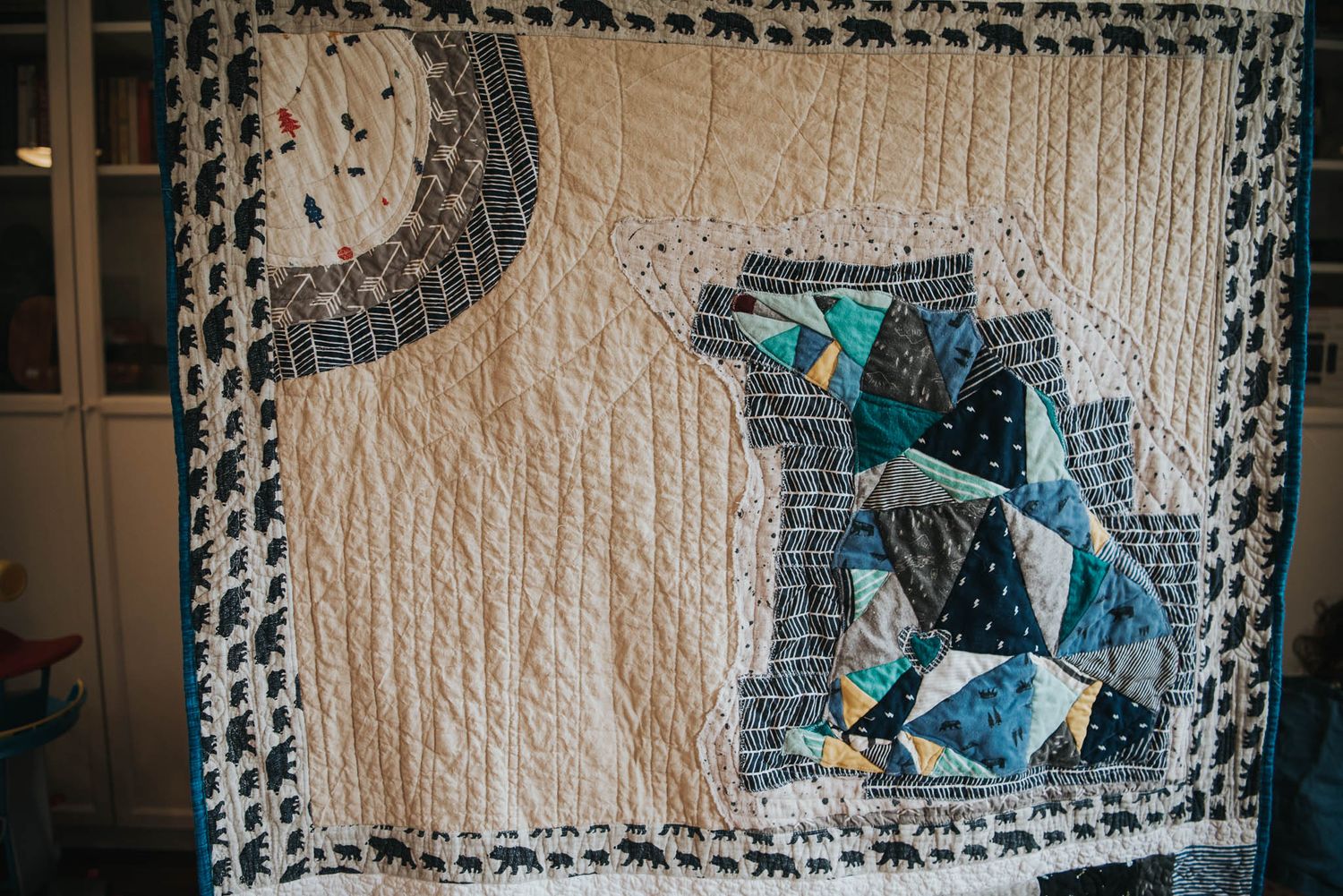 Gorgeous memory quilt featuring a pieced bear made from baby clothes and a sky made from a receiving blanket.