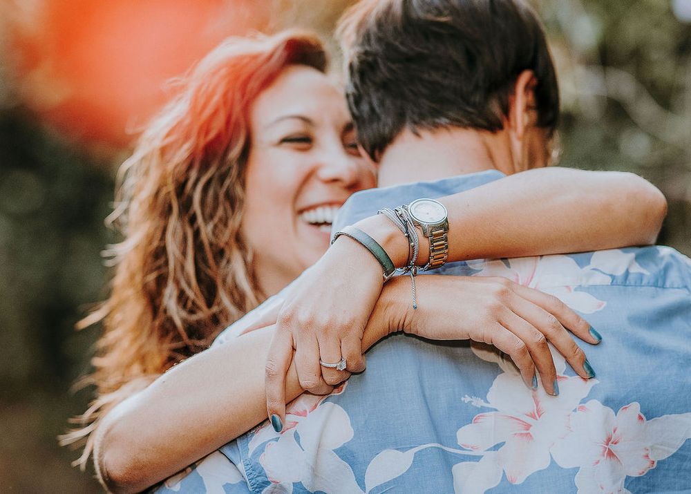 candid captured moment of woman with arms flung around her finaces neck