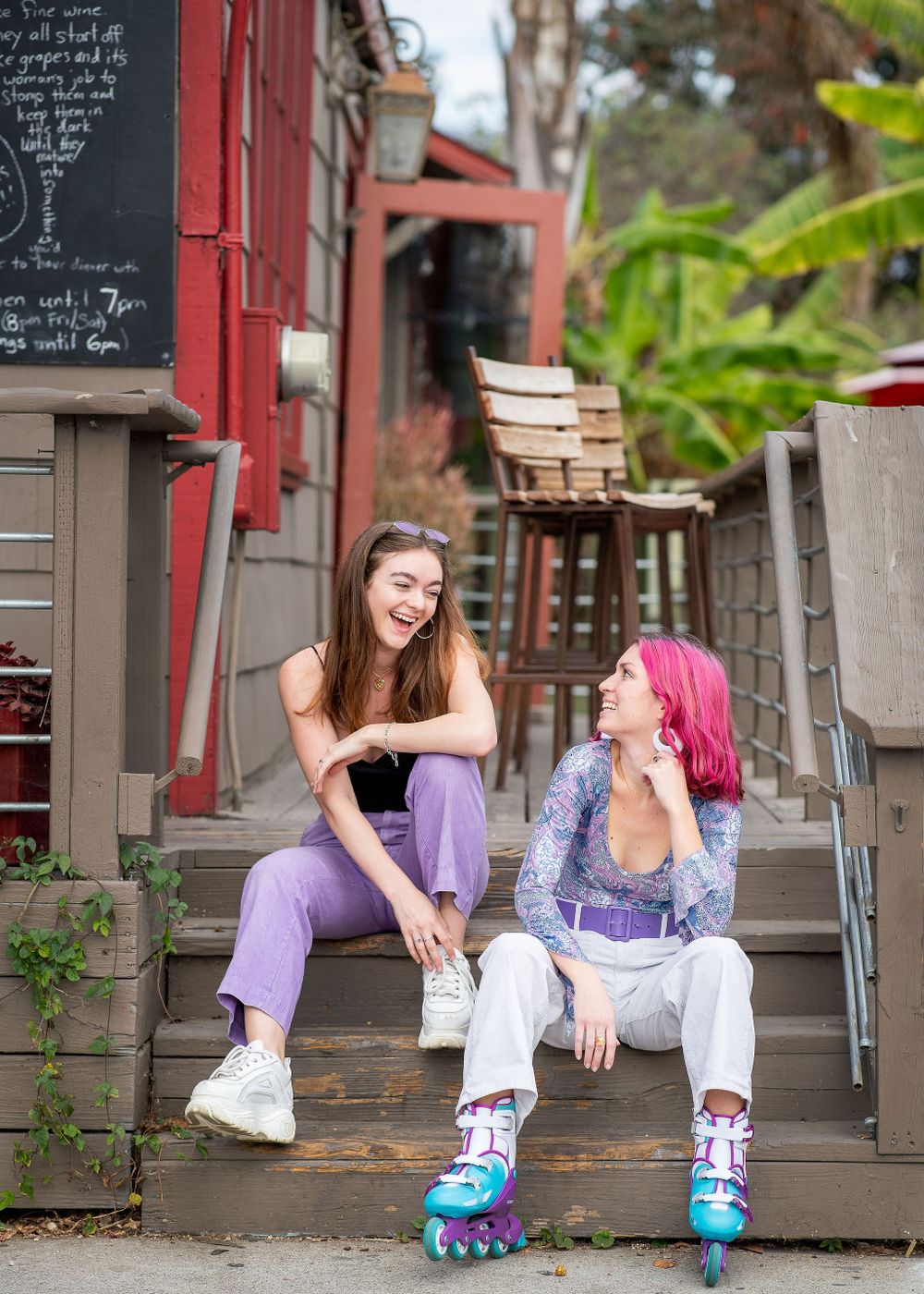 two girls laughing and talking sitting on steps in the funk zone santa barbara ca