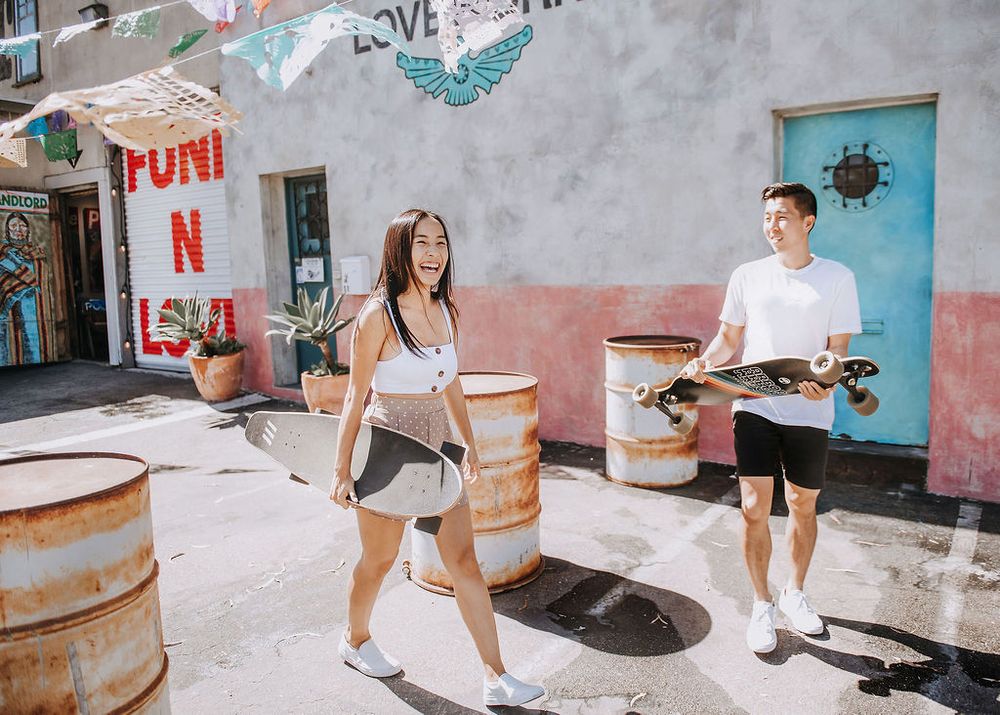 lifestyle portrait of couple playing with skateboards outside in Santa Barbara