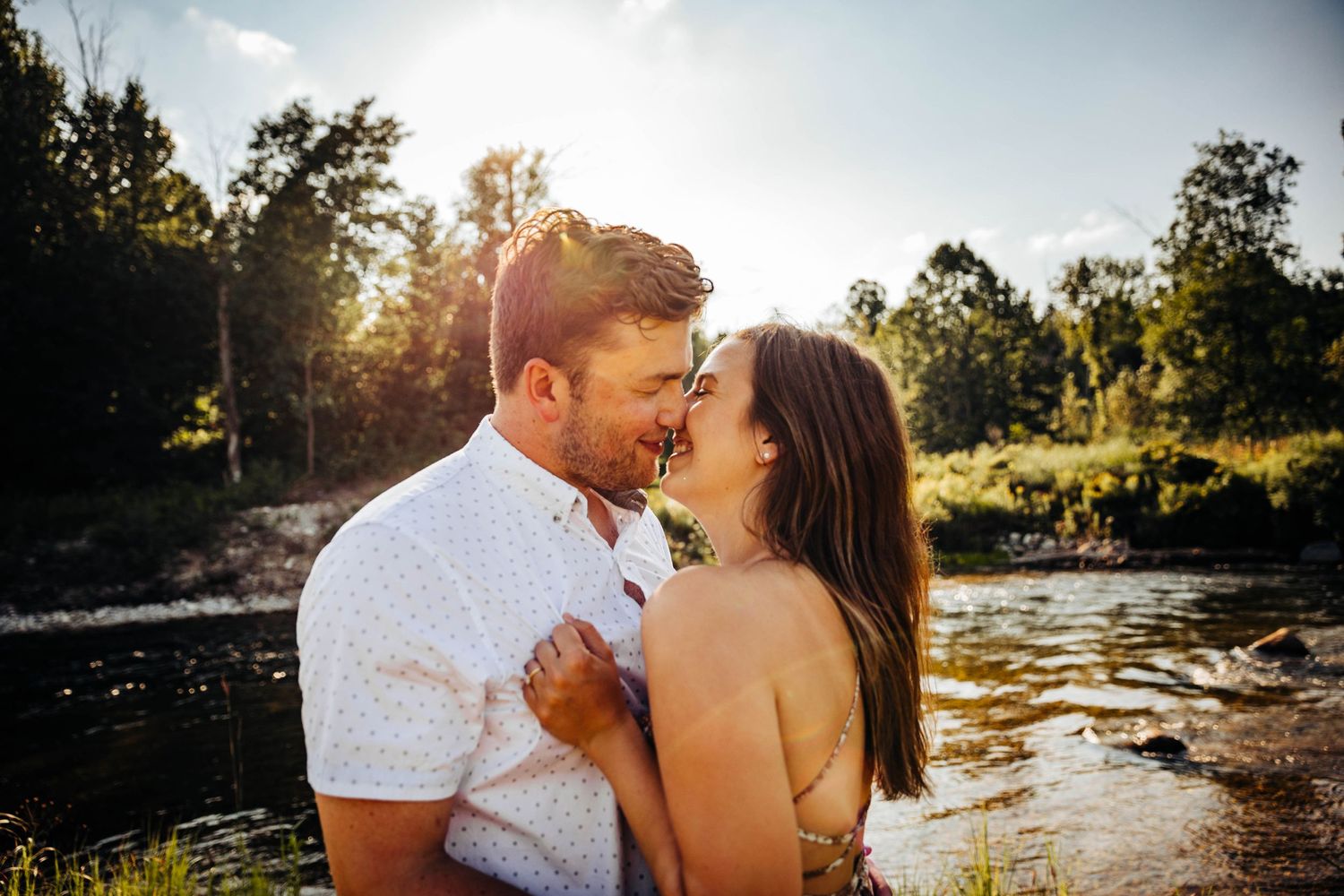 Couple kissing by the river by Traverse City Engagement Photographer Grace Hudson