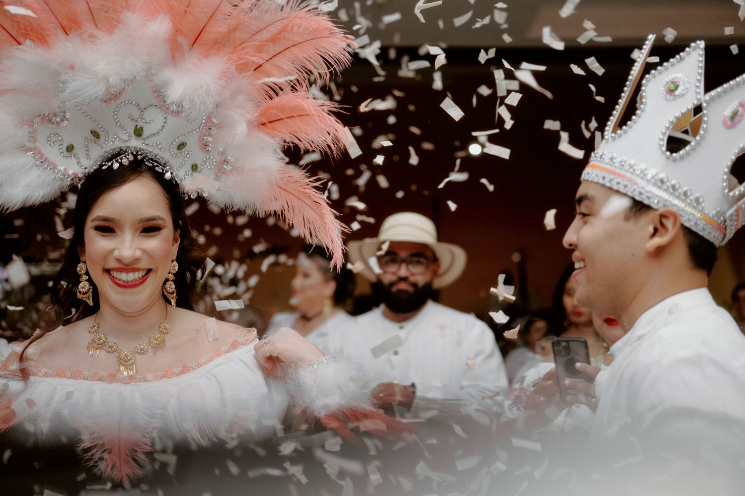 A festive celebration with confetti features dancers in traditional cultural attire.
